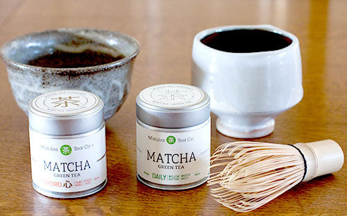 matcha tins, bowl, and whisk on a table