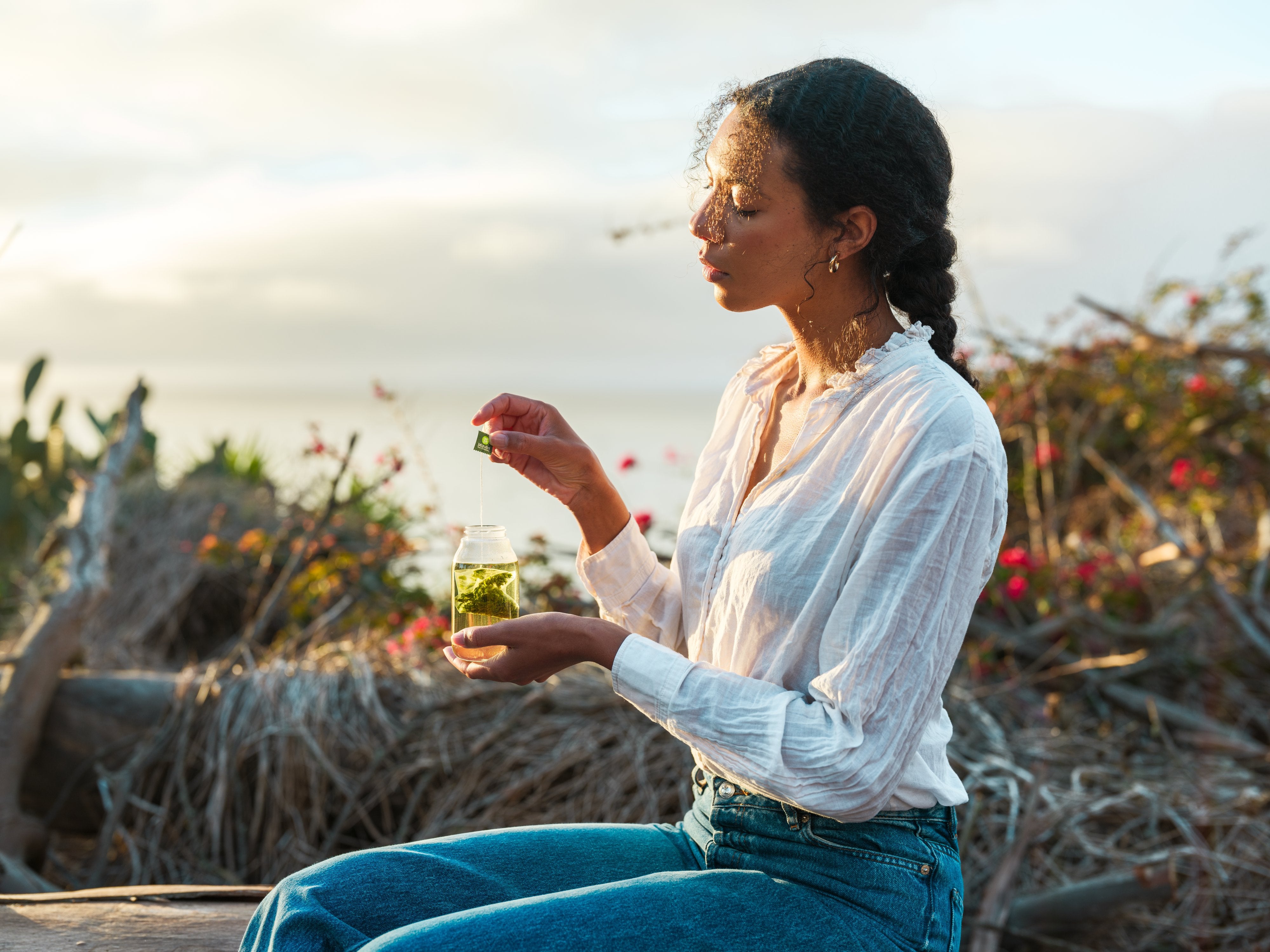 Woman holding a Tea Sachet in a glass cup