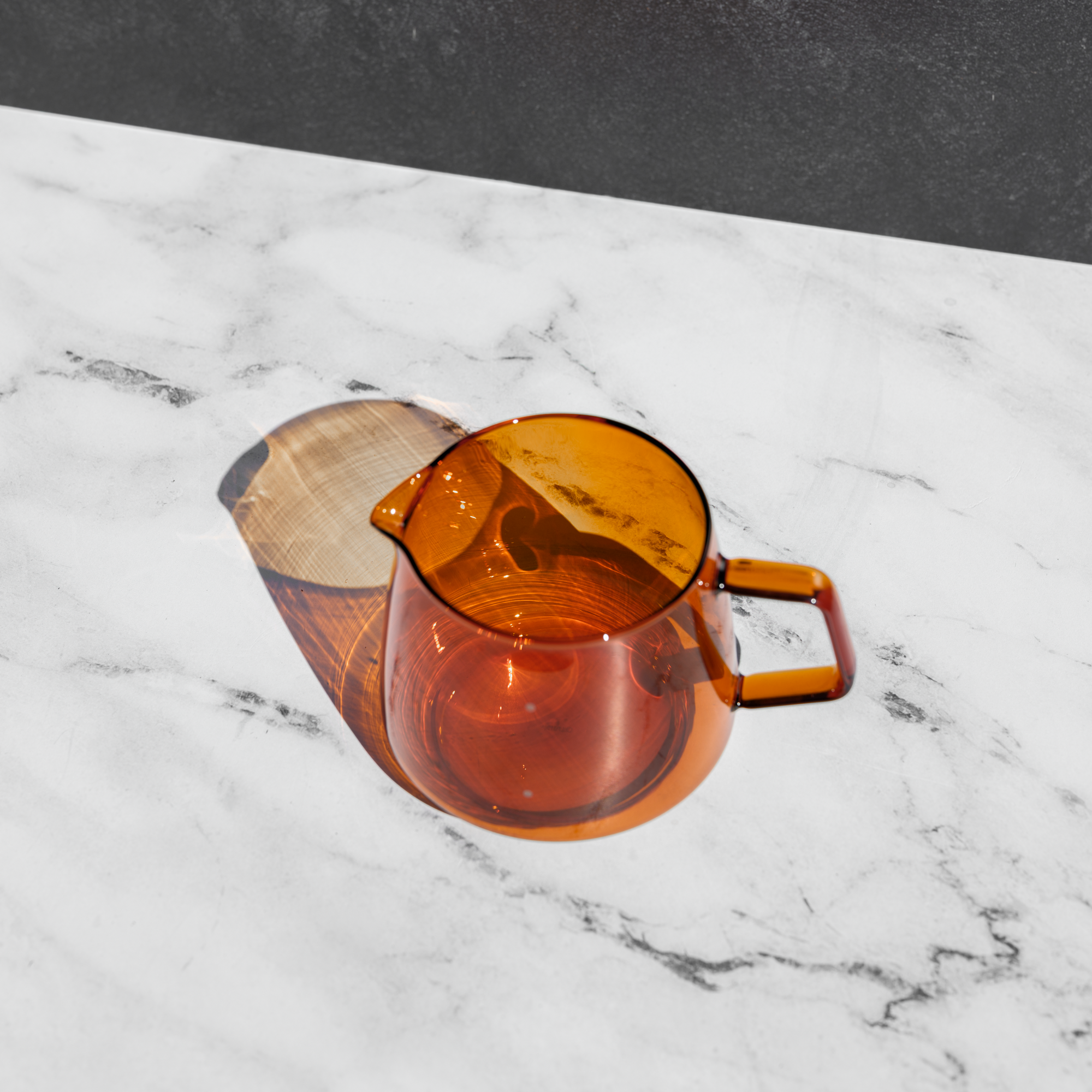 tan colored glass tea pot on a white surface