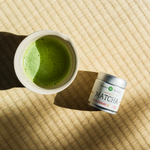 Tsuyuhikari matcha tin  next to brewed matcha