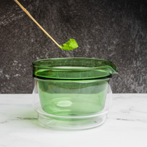 Matcha scoop scooping green matcha powder into green glass chawan