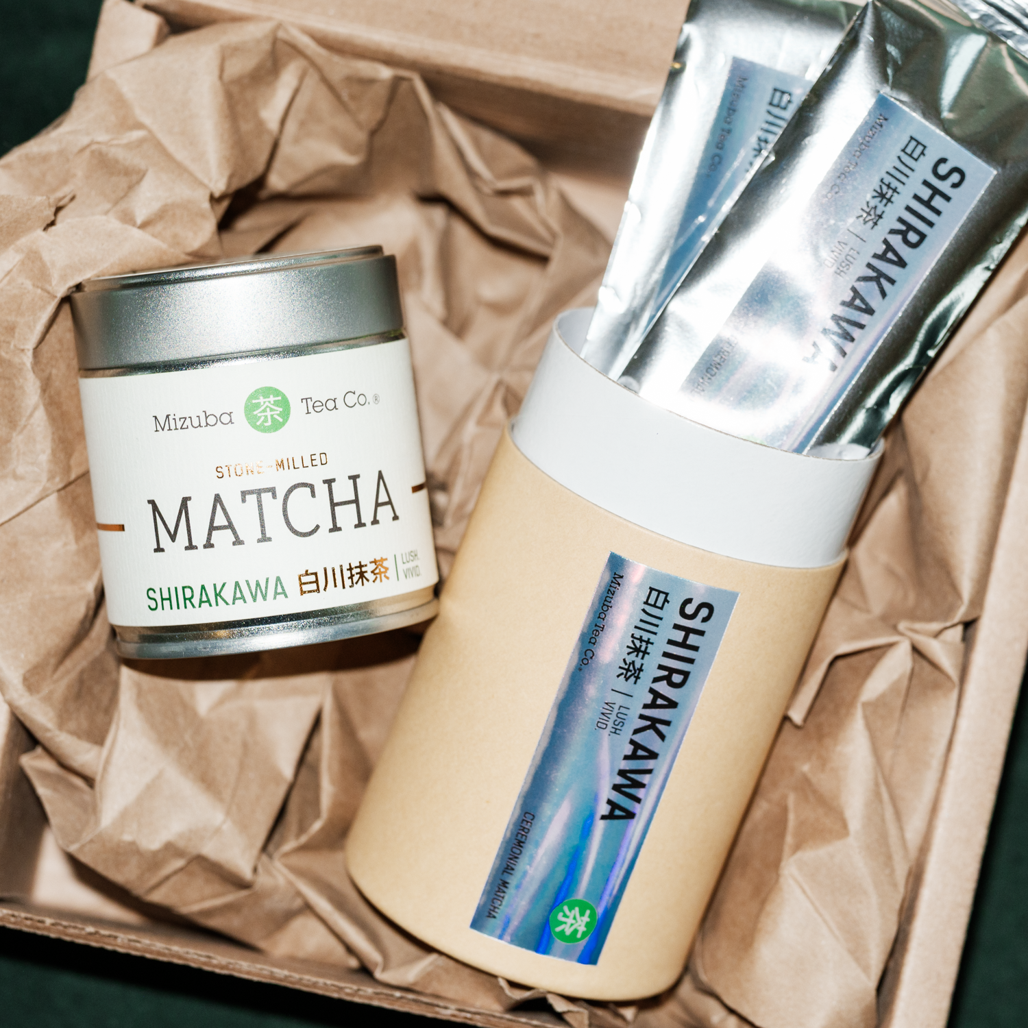 Mizuba Matcha Shirakawa Tsuji San tea canister and packets on brown paper.