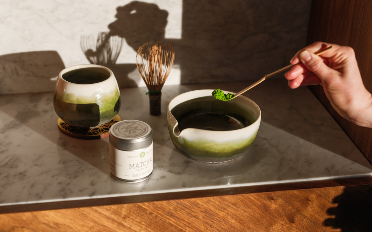 Matcha tea tools with matcha tin on a slate table