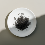 Japanese Wakoucha Shincha Black tea leaves on a white plate with a neutral background