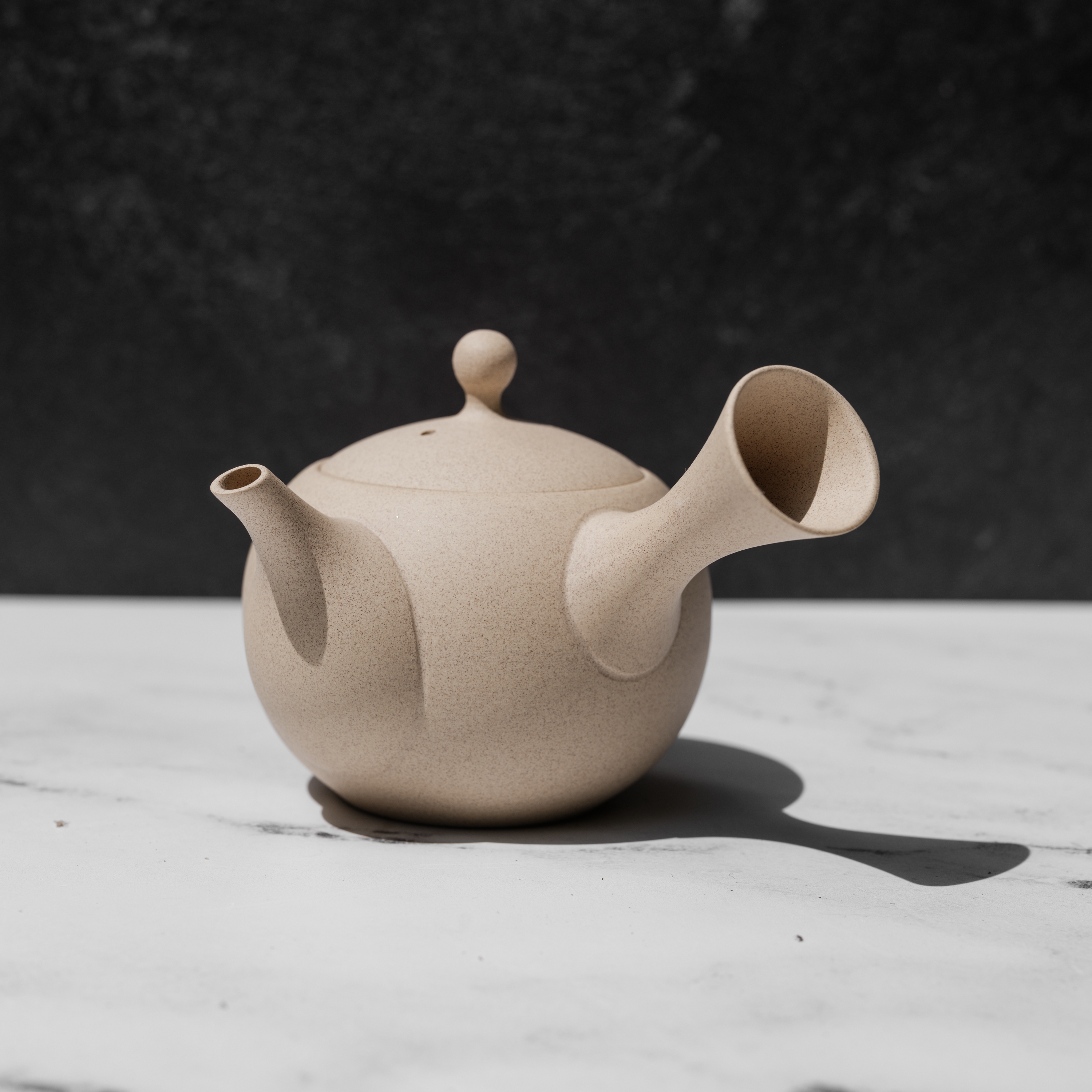 Speckled tea pot on a white surface
