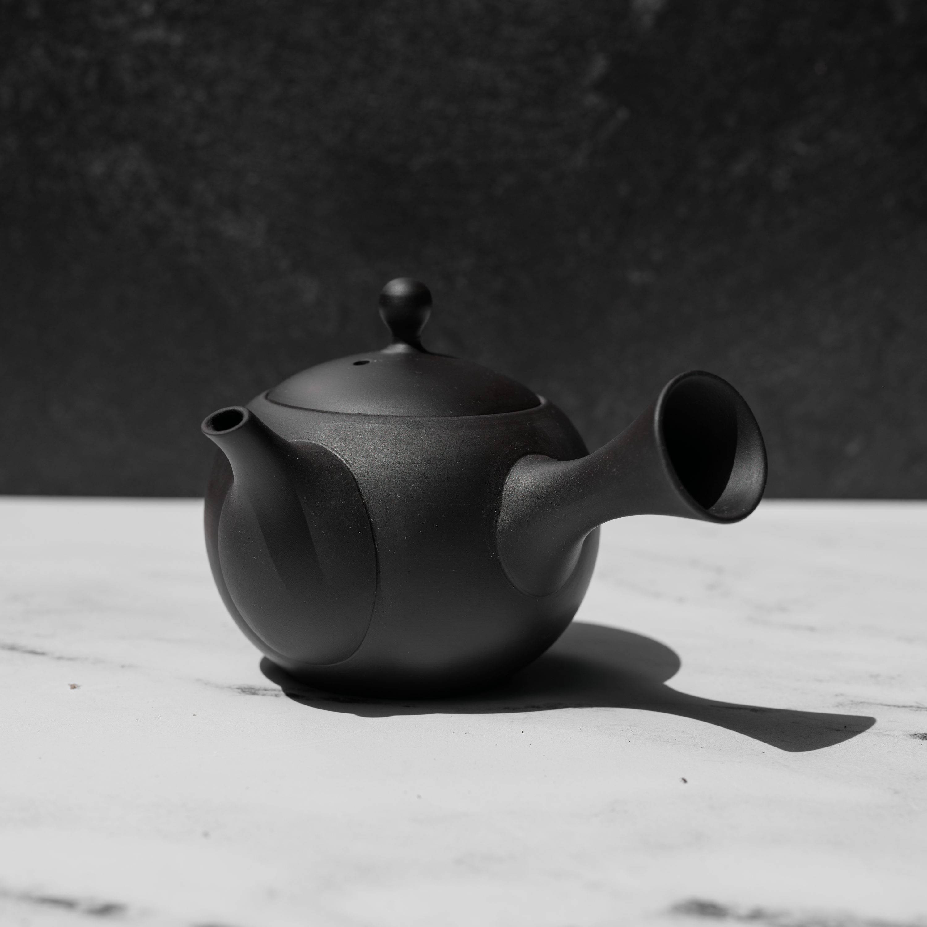 Black tea pot on a white surface