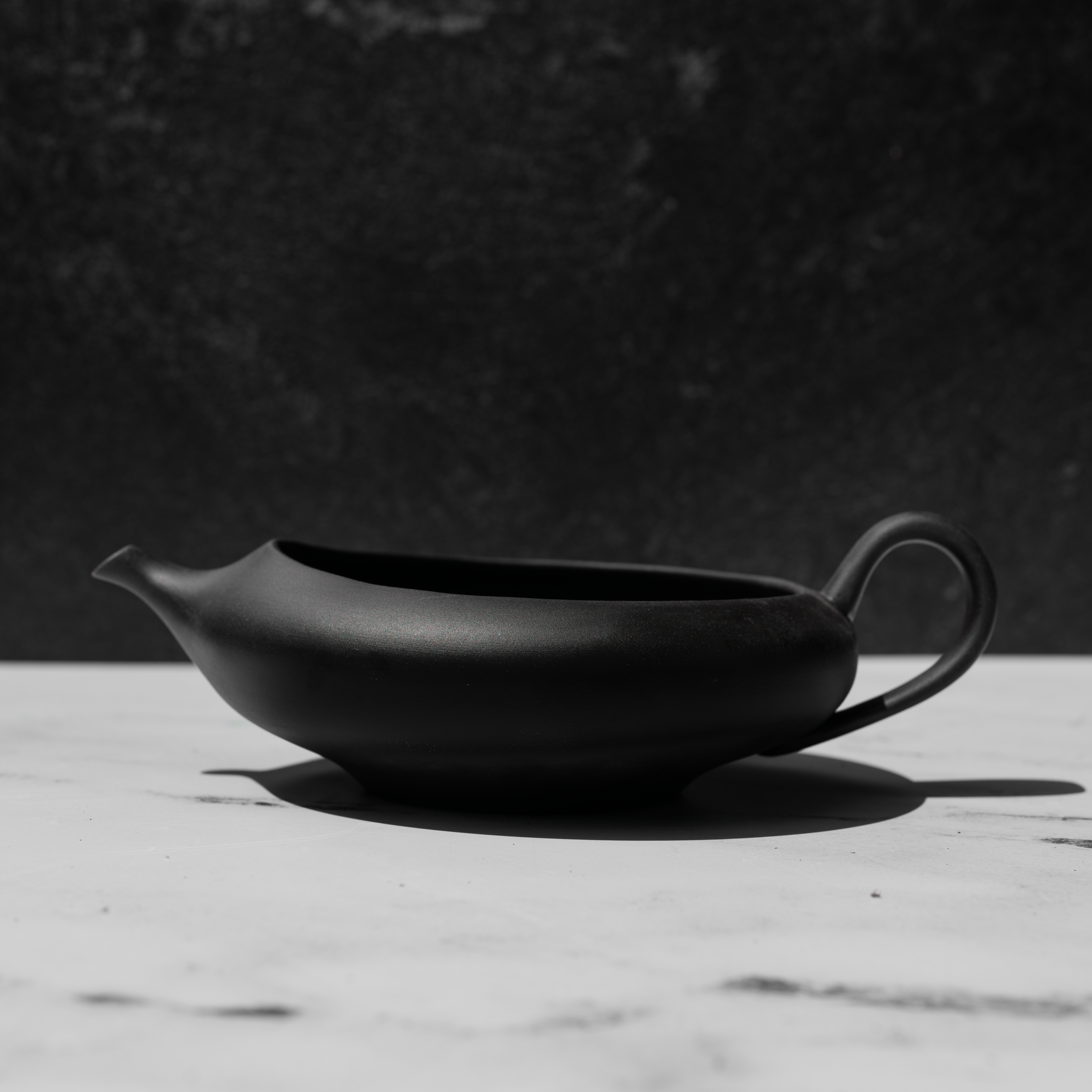 Black tea pot on a white surface