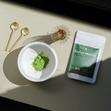 Koshun Matcha powder in a bowl next to a bag of matcha

