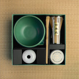 Top view of Mizuba Matcha tin next to a chasen, chawan, and matcha bowl in a box