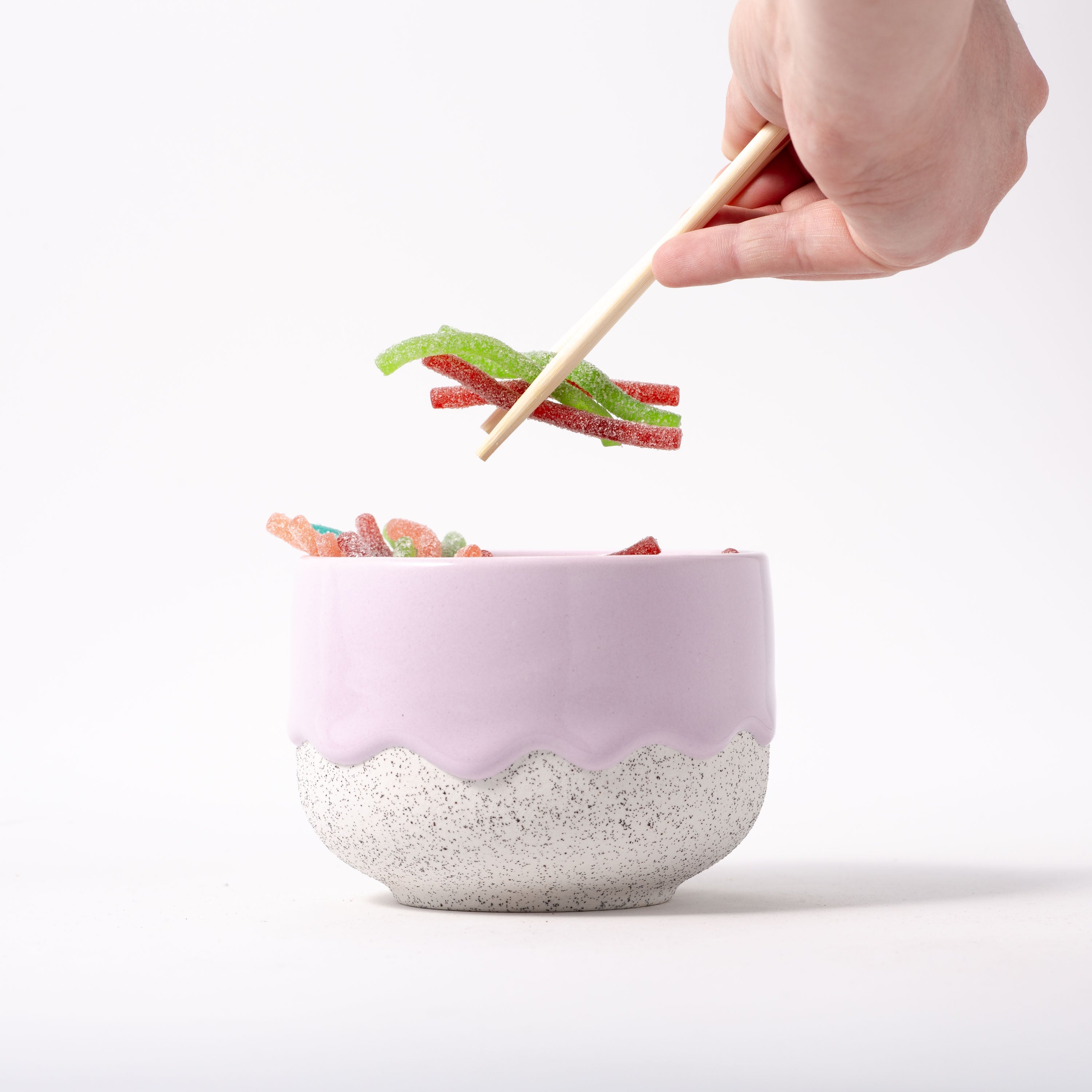 person scooping out gummy snacks from matcha bowl