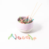 Gummy snacks spelling out "noodle" in front of the noodle tea cup